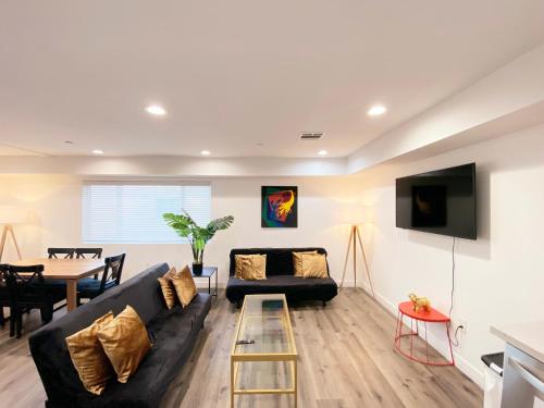 a living room with a black couch and a table at Modern 3BR Home in Mid-City in Los Angeles