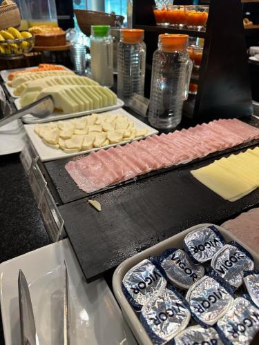 a buffet with different types of meats and cheese at Hotel Saint Paul in Sao Jose do Rio Preto