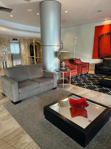 a living room with a couch and a table at Hotel Saint Paul in Sao Jose do Rio Preto