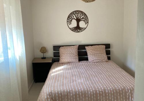 a bedroom with a bed with a tree on the wall at Entre terre et mer in Les Essarts