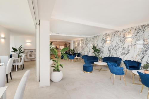 a restaurant with blue chairs and tables and plants at Hotel Villa Domizia in Porto Santo Stefano