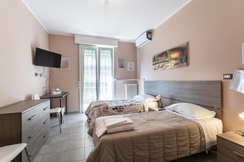 a hotel room with two beds and a desk at FARE BnB - Room & Breakfast Santa Maria in Reggio Emilia