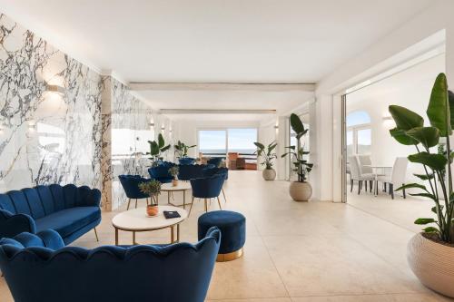 a living room with blue furniture and plants at Hotel Villa Domizia in Porto Santo Stefano