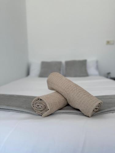 a rolled up towel on top of a bed at Ático en el Centro de Cambados in Cambados