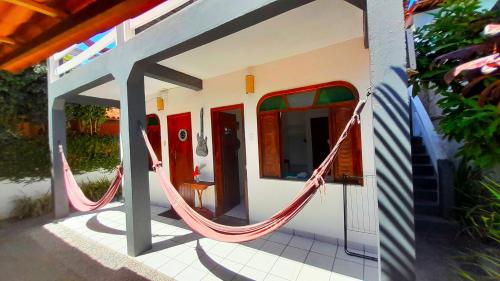 a hammock outside of a house with a porch at Pousada do Rock in Arraial d'Ajuda