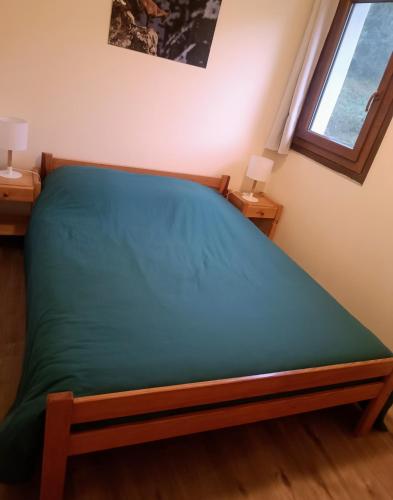 - une chambre avec un lit doté d'un matelas vert dans l'établissement Les Ecureuils 