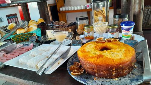 a table with a cake and other foods on it at Pousada do Rock in Arraial d'Ajuda