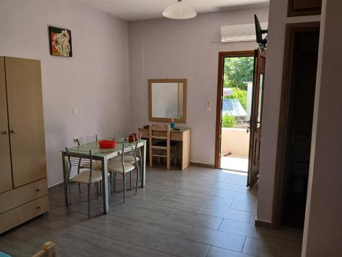 a dining room with a table and chairs and a mirror at Vassilis Studios in Anaxos
