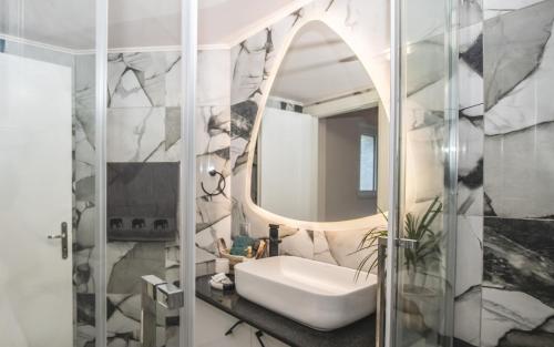a bathroom with a sink and a mirror at Olive Treasure Villa with Private Pool in Kolymbia