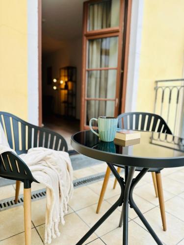 a coffee table and two chairs on a patio at Apartment Altstadtliebe in Bautzen