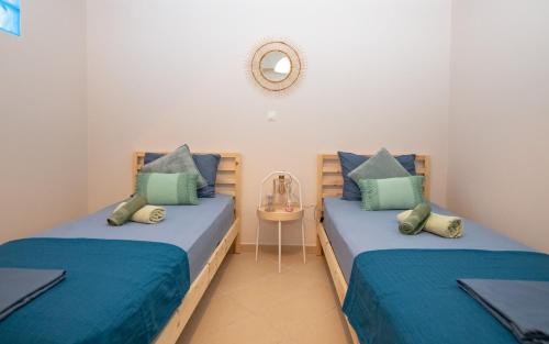 two twin beds in a room with a mirror at Olive Treasure Villa with Private Pool in Kolymbia