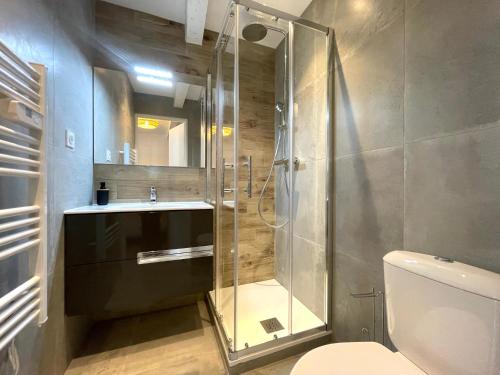 La salle de bains est pourvue d'une douche en verre et de toilettes. dans l'établissement Appartement calme et cosy à deux pas du centre ville, à La Crau
