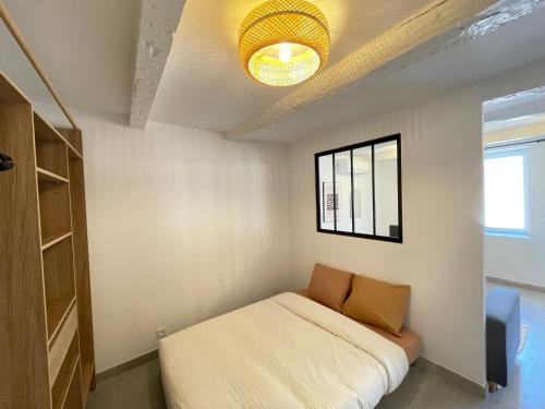 une petite chambre avec un lit et une fenêtre dans l'établissement Appartement calme et cosy à deux pas du centre ville, à La Crau
