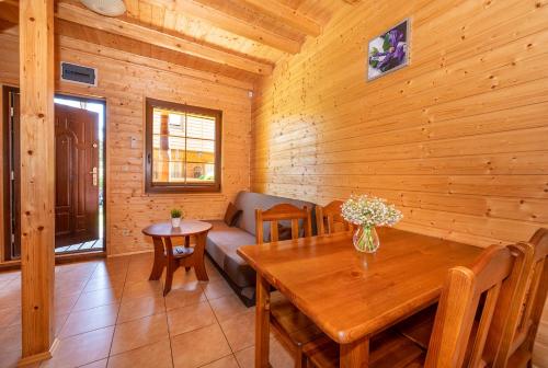 a dining room with a table and a couch at Raj nad Morzem in Bobolin