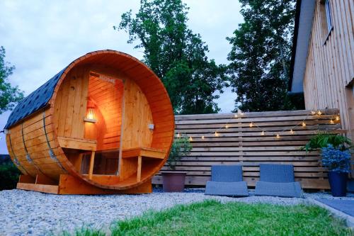 a wooden hobbit house with two chairs in a yard at Ferienhaus Landblick in Warstein