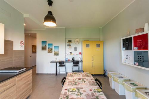 a kitchen with a long table and a yellow cabinet at FARE BnB - Room del Parco in Reggio Emilia