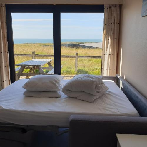- un lit avec des oreillers dans une chambre avec une fenêtre dans l'établissement studio Vue sur baie, à Wimereux