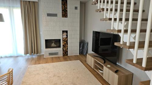 a living room with a fireplace and a staircase at Rest Village 5A Trzęsacz in Pustkowo