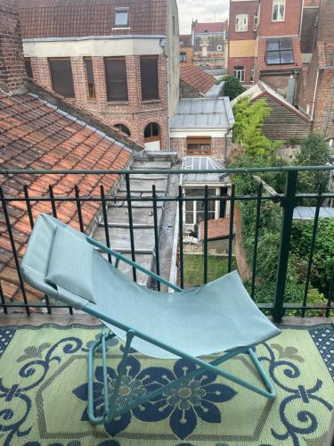 une chaise bleue assise au-dessus d'un balcon dans l'établissement Appartement de charme, à Lille