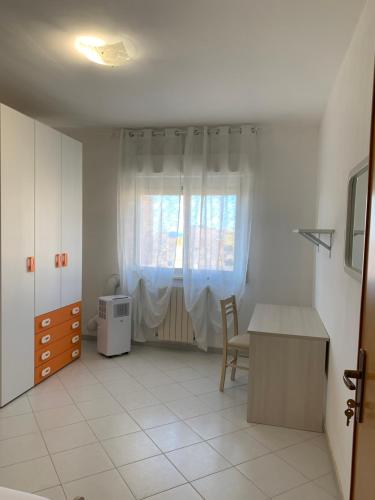 een witte kamer met een tafel en een raam bij Perla marina in Casa Santa