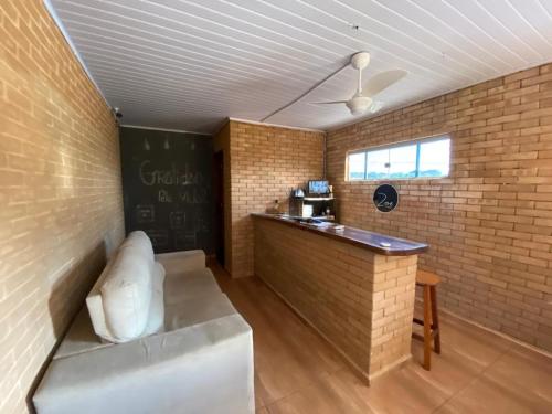 a room with a couch and a bar in a brick wall at Pousada Zoe in Pirenópolis
