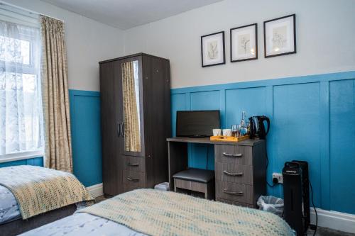 a bedroom with a bed and a desk with a computer at Hesketh Hotel in Blackpool