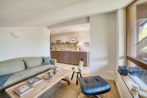 un salon avec un canapé et une table dans l'établissement Bel appartement au dernier étage - Megève, à Megève