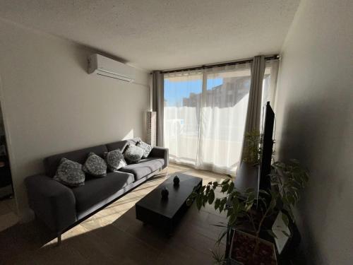 a living room with a couch and a large window at Departamento nuevo dos dormitorios in Curicó