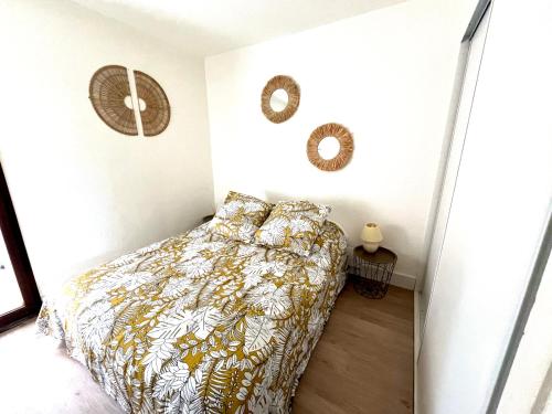 - une chambre avec un lit et une couette jaune et blanche dans l'établissement IPANEMA piscine, plage 4 couchages, au Cap d'Agde