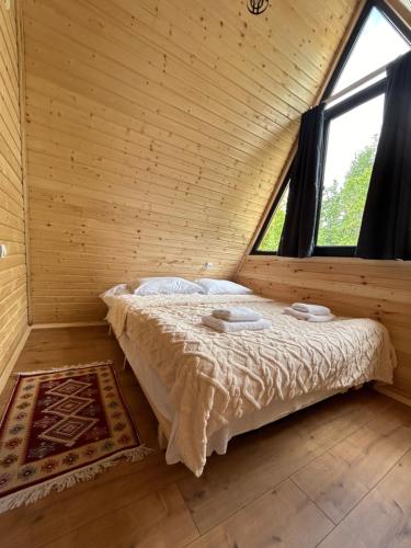 a bed in a wooden room with a window at Villa Wood in Mestia N 2 in Mestia