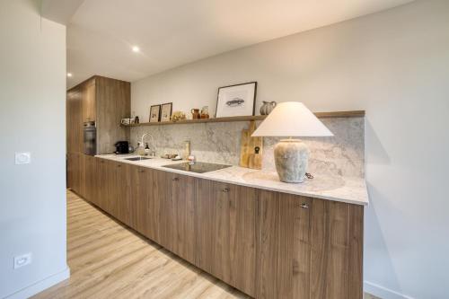 une cuisine avec un grand îlot avec une lampe dessus dans l'établissement Bel appartement au dernier étage - Megève, à Megève