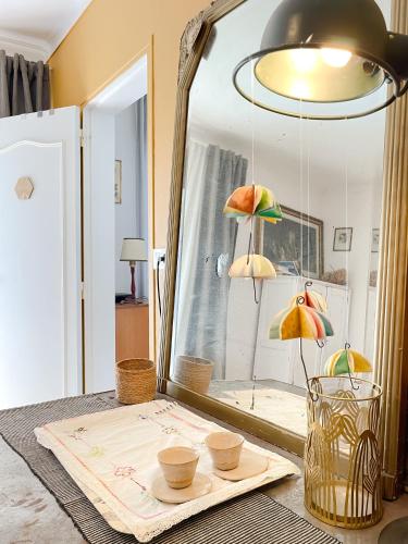 une table avec un miroir et quelques bols et parasols dans l'établissement Maison de Charles, à Sougéal