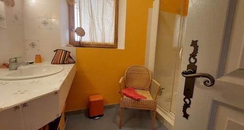 y baño con lavabo, silla y espejo. en Freundliches Haus mit Pool und großem Garten, en Buis-les-Baronnies