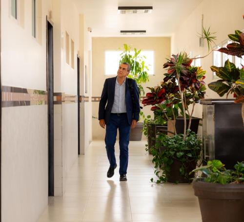 a man walking down a hallway in an office at Villa Las Margaritas Caxa in Xalapa