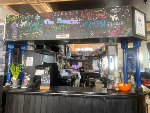 a bar with graffiti on the top of it at The Phoenix Hostel Paddington in London