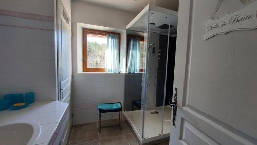 a bathroom with a shower and a sink and a chair at Freundliches Haus mit Pool und großem Garten in Buis-les-Baronnies