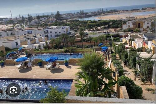 a resort with a swimming pool and a beach at Duplex 2 pour les familles in Oualidia