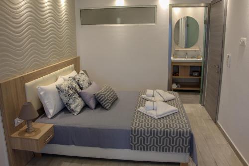 małą sypialnię z łóżkiem i lustrem w obiekcie Thea-tro Apartments w mieście Limenas