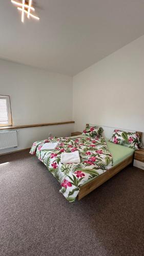 a bedroom with a bed with a floral bedspread at Penzion Slovácko 2 in Ostrožská Nová Ves