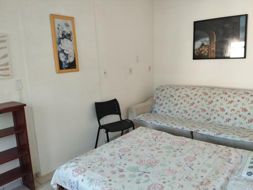 a small bedroom with a bed and a chair at Suite Praias Penha SC in Penha