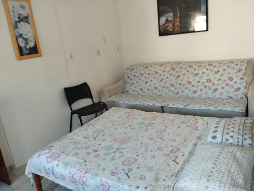 a bedroom with two beds and a chair at Suite Praias Penha SC in Penha