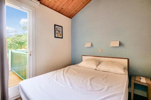 - une chambre avec un lit et un balcon avec une fenêtre dans l'établissement Résidence Port Bourgenay - maeva Home - Appartement 3 pièces 5 personnes - Sélection MAE-6791, à Talmont-Saint-Hilaire