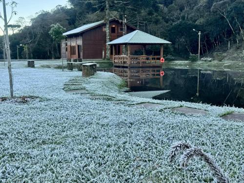 a snow covered field with a house and a building at Vila Vert - Rancho Queimado - SC in Rancho Queimado