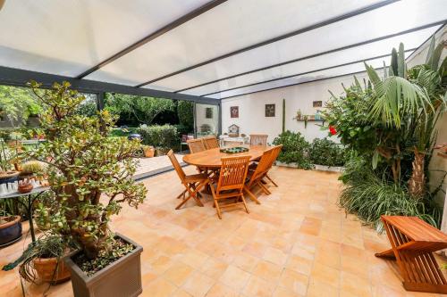 un patio avec une table, des chaises et des plantes en pot dans l'établissement 