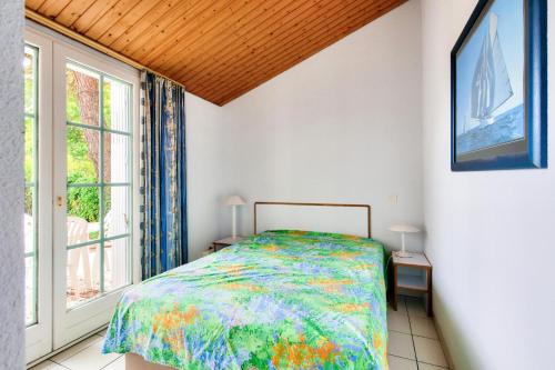 une chambre avec un lit et une grande fenêtre dans l'établissement Résidence Port Bourgenay - maeva Home - Appartement 3 pièces 7 personnes - Sélection MAE-5431, à Talmont-Saint-Hilaire