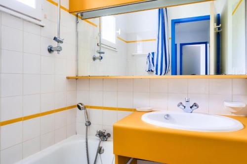 une salle de bain avec un lavabo, un miroir et une baignoire dans l'établissement Résidence Port Bourgenay - maeva Home - Appartement 3 pièces 7 personnes - Sélection MAE-5431, à Talmont-Saint-Hilaire