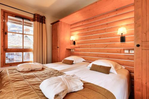 two beds in a room with wooden walls at Résidence Les Arcs 1950 Le Village - maeva Home - Appartement 2 pièces 4 personnes - Prestige MAE-2911 in Arc 1950