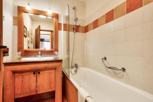 a bathroom with a tub and a sink and a mirror at Résidence Les Arcs 1950 Le Village - maeva Home - Appartement 2 pièces 4 personnes - Prestige MAE-2911 in Arc 1950