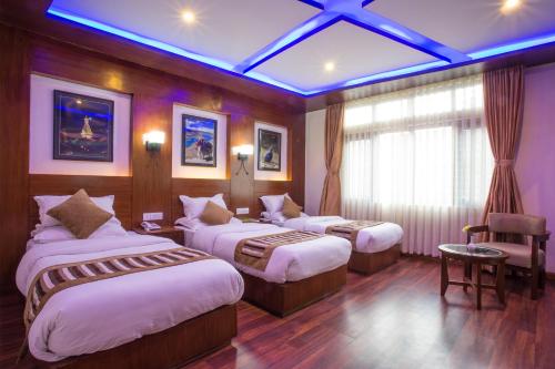 a hotel room with two beds and a window at Aryatara Kathmandu Hotel in Kathmandu