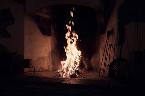 a fire in a fireplace in a dark room at Le Corti Dei Sassi in Berbenno di Valtellina